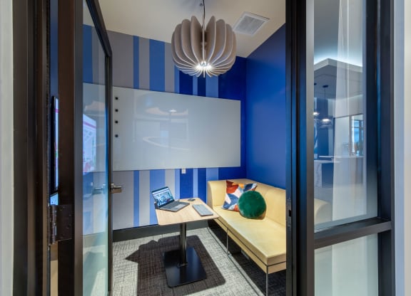 a desk with a laptop in a room with a window