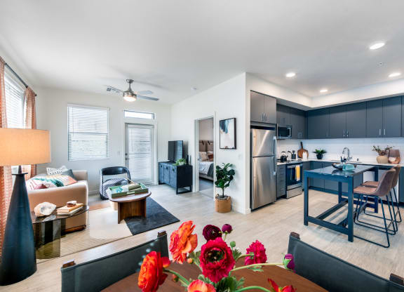 a living room with a dining room and a kitchen with a table and chairs