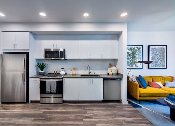 a kitchen with white cabinets and a stainless steel refrigerator