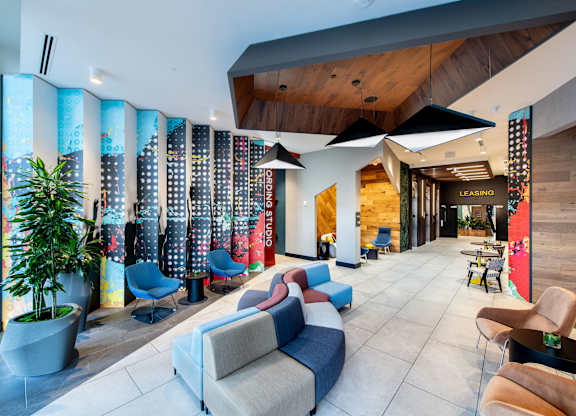 A modern living room with a large sectional sofa and a wooden ceiling.