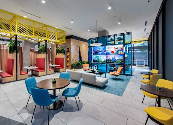 A modern dining area with a yellow lattice structure and blue chairs.