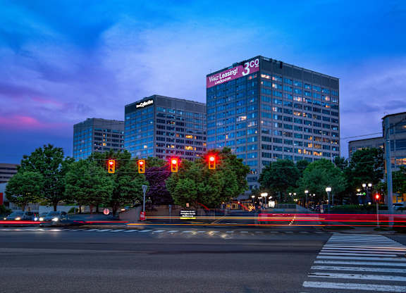 A city street at dusk with traffic lights and buildings.
