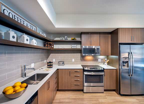 A modern kitchen with a refrigerator, sink, and stove.