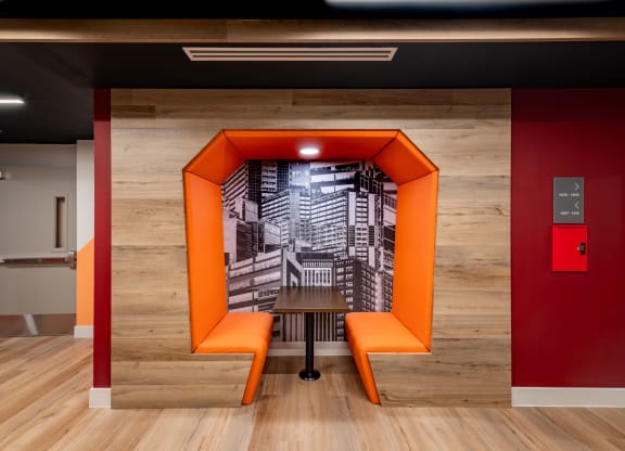 a staircase in a room with orange benches and a table
