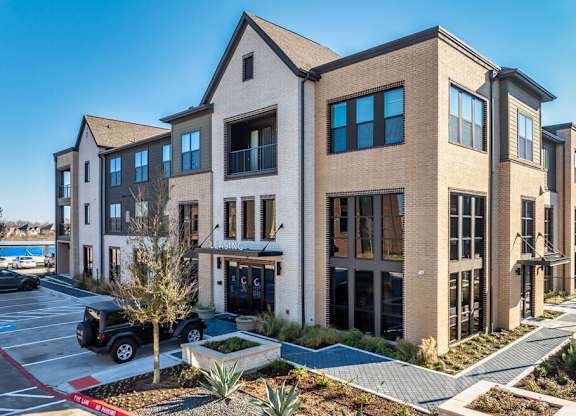 A modern building with a parking lot in front.