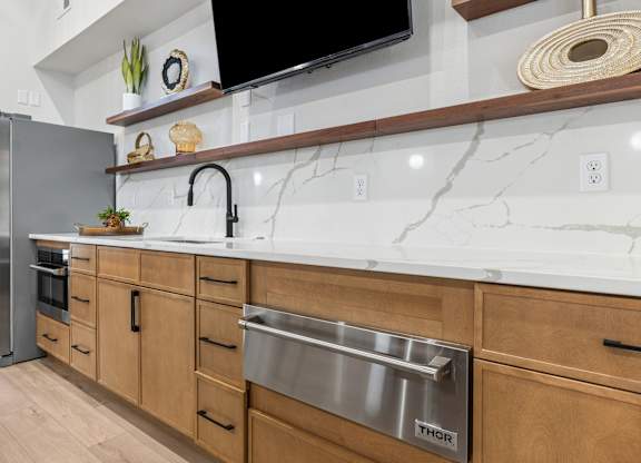 A kitchen with a marble countertop and wooden cabinets.