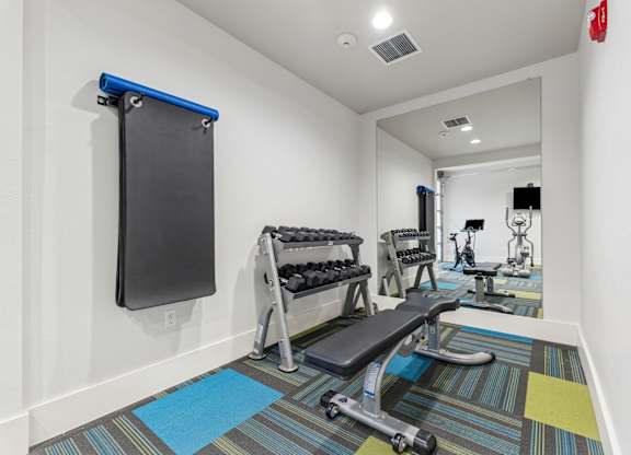 A gym room with a row of exercise equipment.