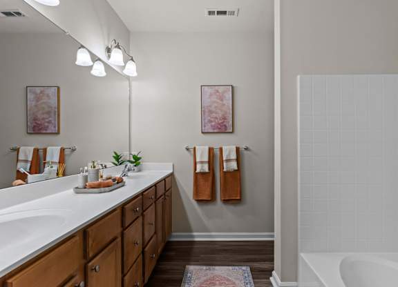 A bathroom with a white tub and a white sink.
