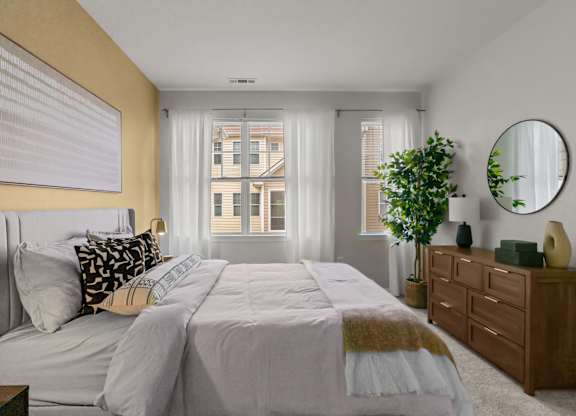 A bedroom with a large bed, a dresser, and a mirror.