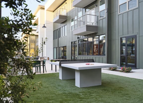 a ping pong table in the backyard of a building