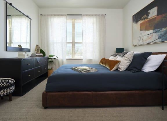 a bedroom with a large bed and a dresser