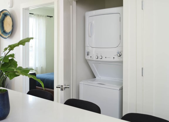a white washer and dryer in a white laundry room
