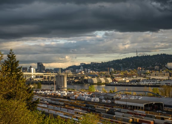 a view of the city from a hill overlooking the water with trains