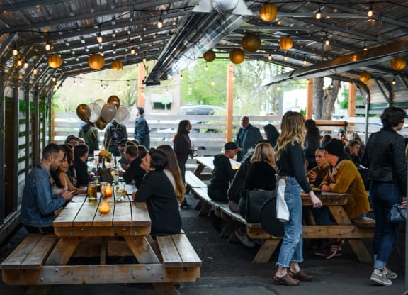 a group of people sitting at tables in a beer tent