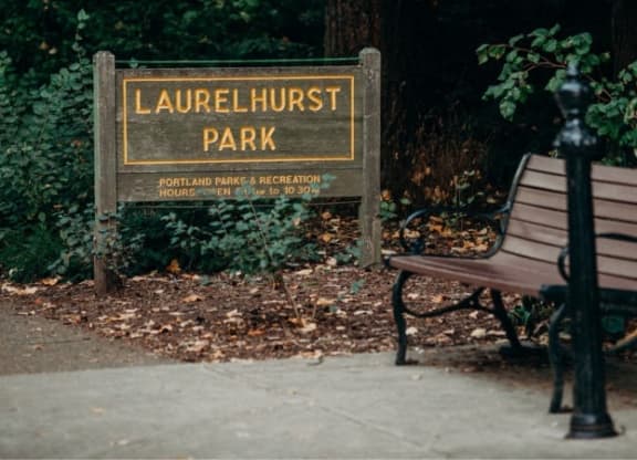 a park bench sitting in front of a park sign