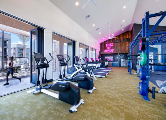 a gym with cardio equipment and windows at aria resort and spa