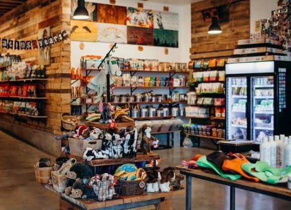 a woman walking into a store with a display of shoes