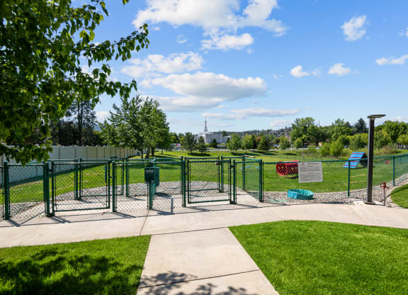 a fenced in area of a park with playground equipment
