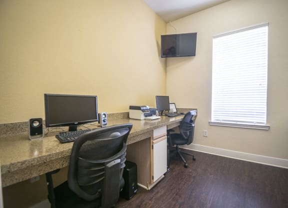 an office with a desk with a computer and a monitor at Fountains of Denton in Denton, TX