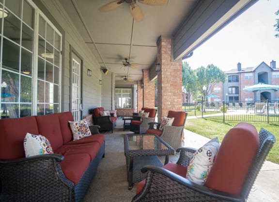a covered porch with furniture and a ceiling fan at Fountains of Denton in Denton, TX