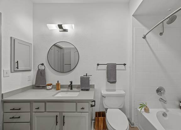 A bathroom with a white tub, toilet, and sink.