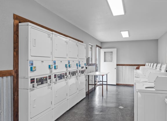 a room with white cabinets and a table with a laptop on it