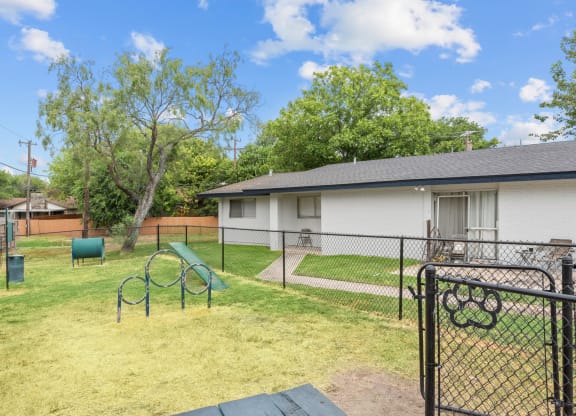 a backyard with a play area and a house in the background
