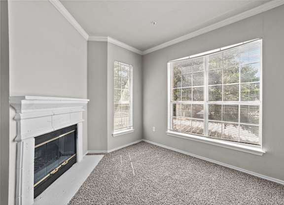 A room with a fireplace and a window with blinds.