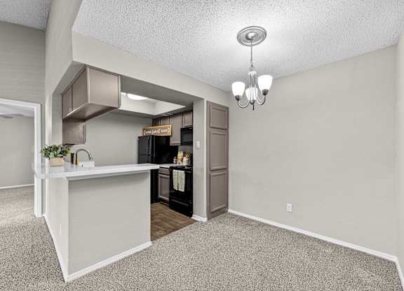 A kitchen area with a white counter and a refrigerator.