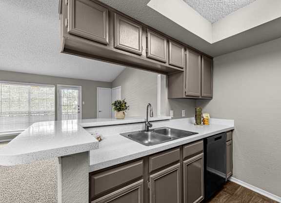 A kitchen with brown cabinets and a white countertop.