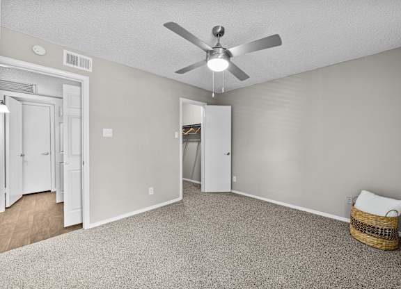 A room with a ceiling fan and a carpeted floor.