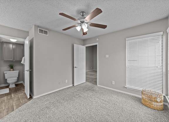 A room with a ceiling fan and a carpeted floor.