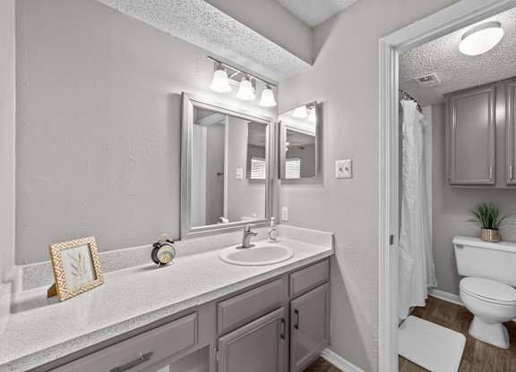 A bathroom with a white sink and a white toilet.