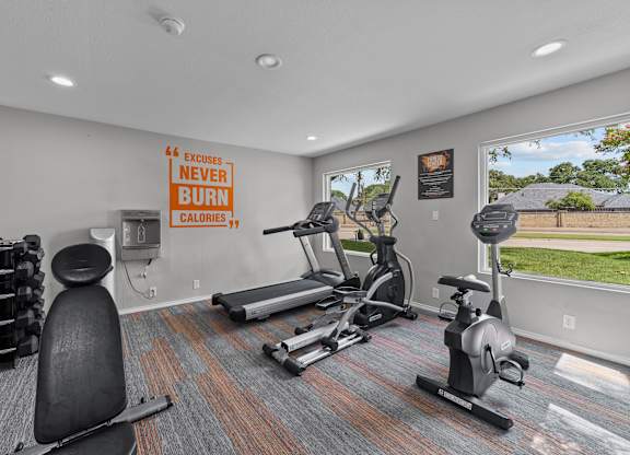 A gym room with a sign that says "Excuses Never Burn Calories".