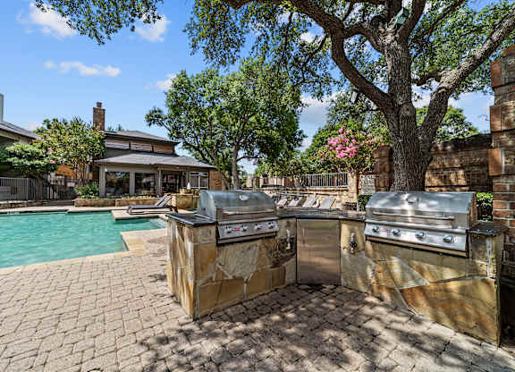 A backyard with a grill and a pool.