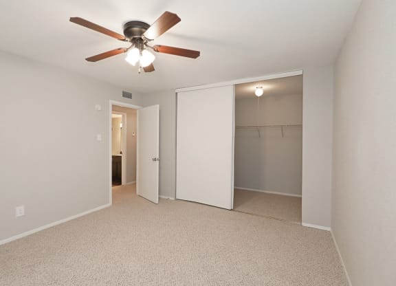 a bedroom with a ceiling fan and closet