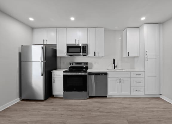a white kitchen with stainless steel appliances and white cabinets at Sunset Heights, San Antonio, 78209