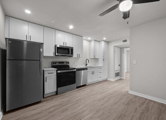 an empty kitchen with white cabinets and stainless steel appliances at Sunset Heights, Texas
