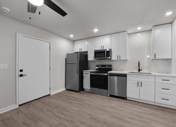 an empty kitchen with white cabinets and stainless steel appliances at Sunset Heights, Texas, 78209