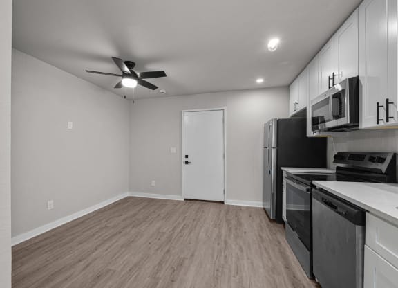 the living room of a home with a kitchen and a ceiling fan at Sunset Heights, San Antonio, TX, 78209