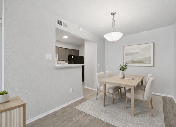 A dining room with a wooden table and chairs.