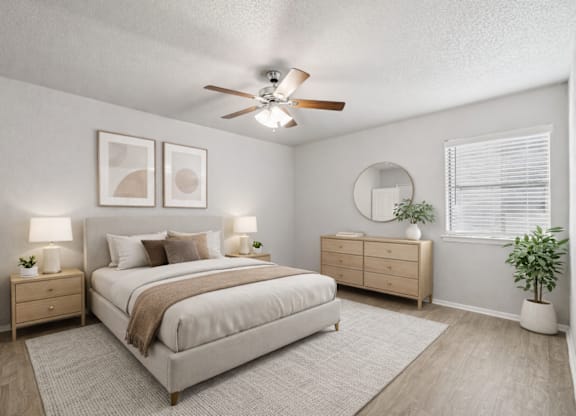 A bedroom with a bed, nightstands, and a ceiling fan.