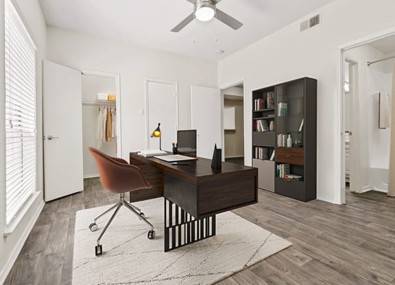 the residence on lamar apartment homes has an office with a desk and a chair