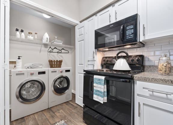 a laundry room with a washer and dryer and a white washer at Fountains of Denton in Denton, TX