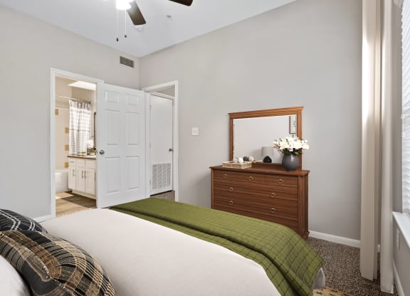 a bedroom with a bed and a dresser with a mirror