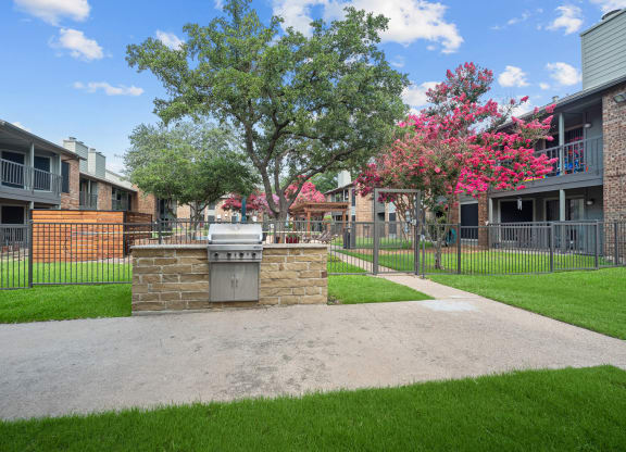 an outdoor barbecue area at legacy apartments in plano, tx