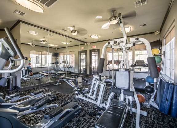 Exclusive Fitness Center with cardio machine and free weights at Fountains of Denton Apartments in Denton, TX
