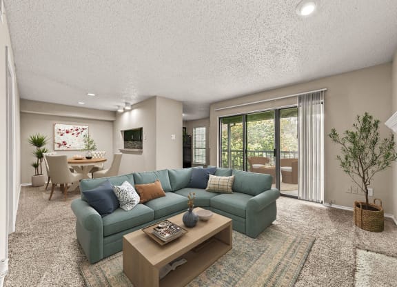 a living room with a blue couch and a coffee table at Legacy Apartments in Plano, TX