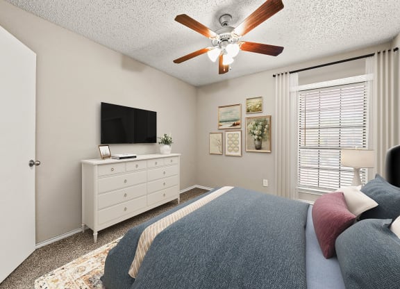 a bedroom with a bed and a ceiling fan
