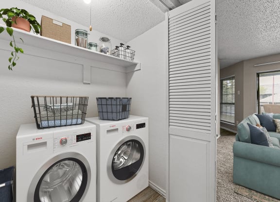 a washer and dryer in a laundry room with a couch